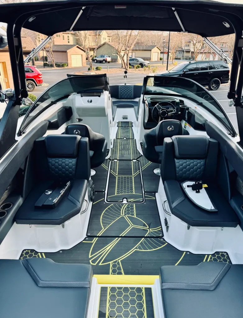gallery-10 Luxury boat interior with black seating, yellow-accented floor, and open windshield by a suburban street.