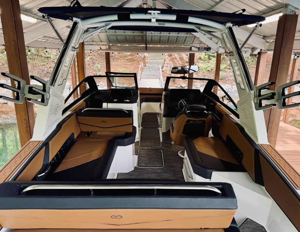 gallery-33 Luxury boat interior with brown and black seating, under a metal roof at a dock, empty and neat.