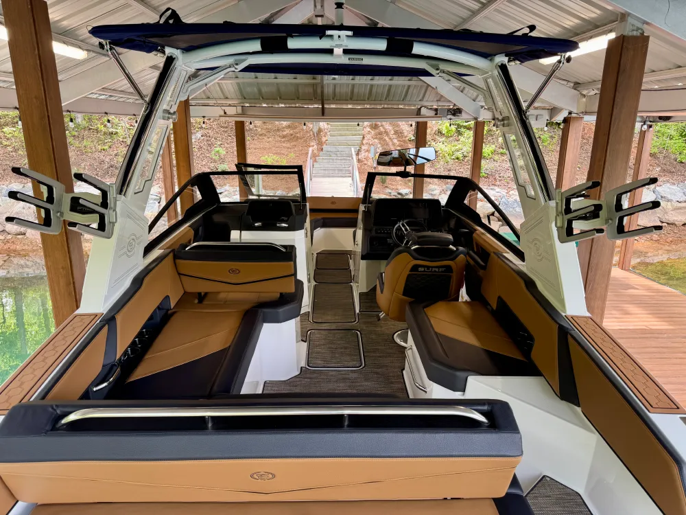 gallery-34 Luxury motorboat interior with brown and black seating, covered dock, and water visible on the left side.