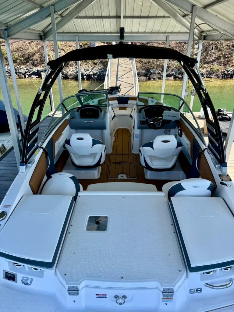 gallery-5 Open bow white and brown motorboat docked under a covered pier, with four white seats in view.