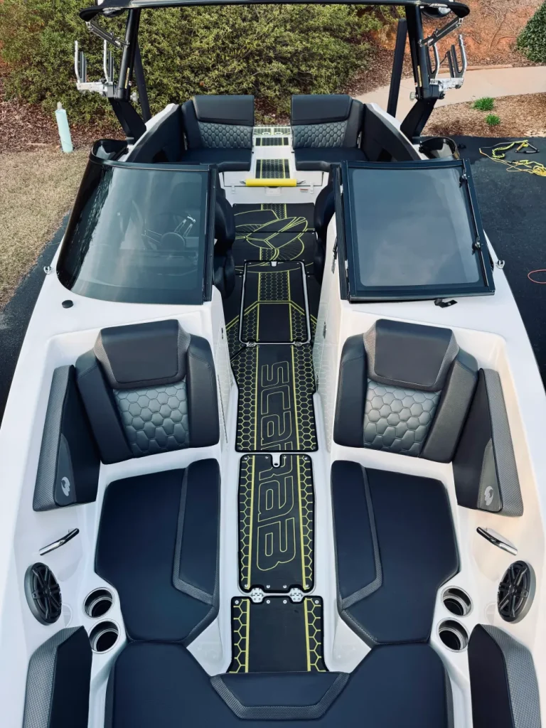 gallery-9 Top view of a modern speedboat with black, gray, and yellow seats, open windshields, and speakers.